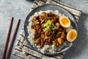Home made taiwanese braised pork belly with hard boiled eggs on a plate with chopsticks