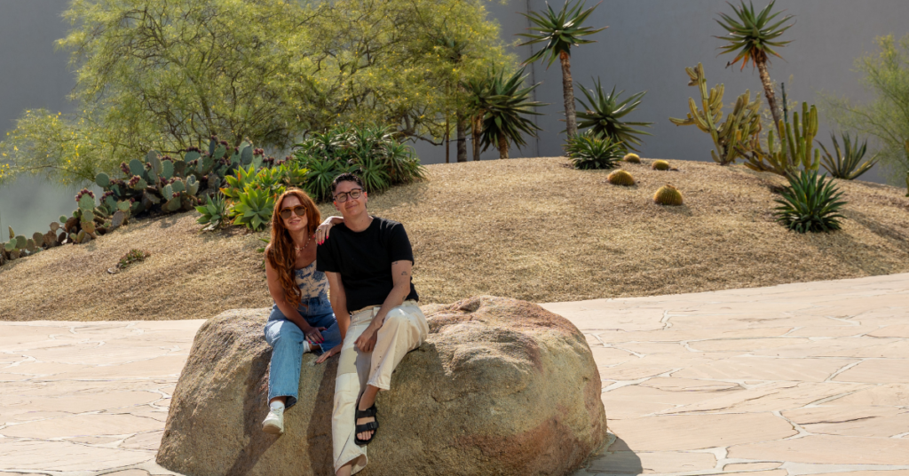 two queer people sitting in an outdoor art instilation in Costa Mesa