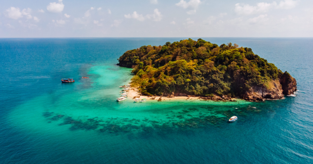 island surrounded by crystal blue water and sany beach