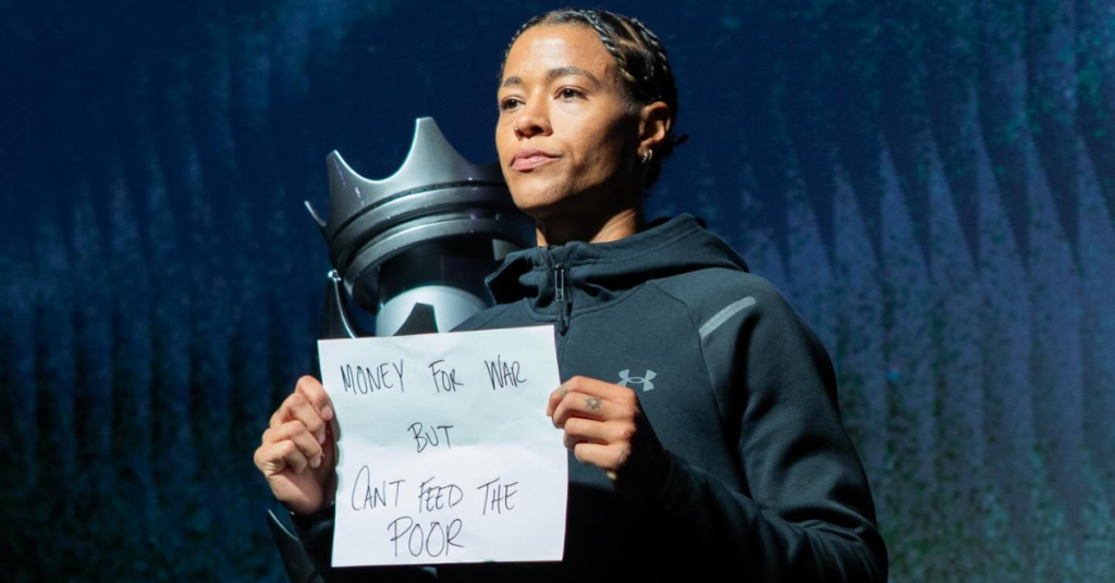 WNBA player Tasha Cloud holding up an anti war sign before playing a game