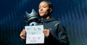 WNBA player Tasha Cloud holding up an anti war sign before playing a game