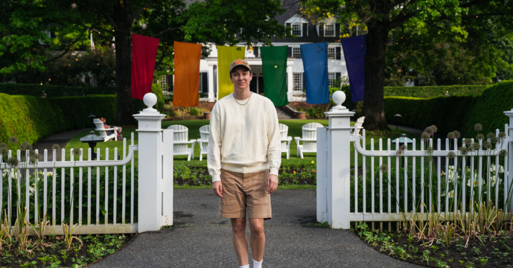 queer person in front of the Woodstock Inn and Resort in Woodstock Vermont during Pride